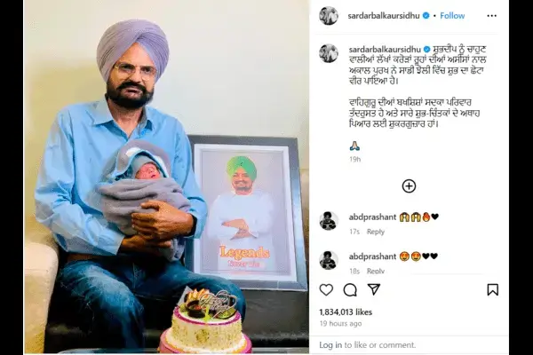 Sidhu Moose Wala's father is holding the child in his hand, wearing a blue shirt